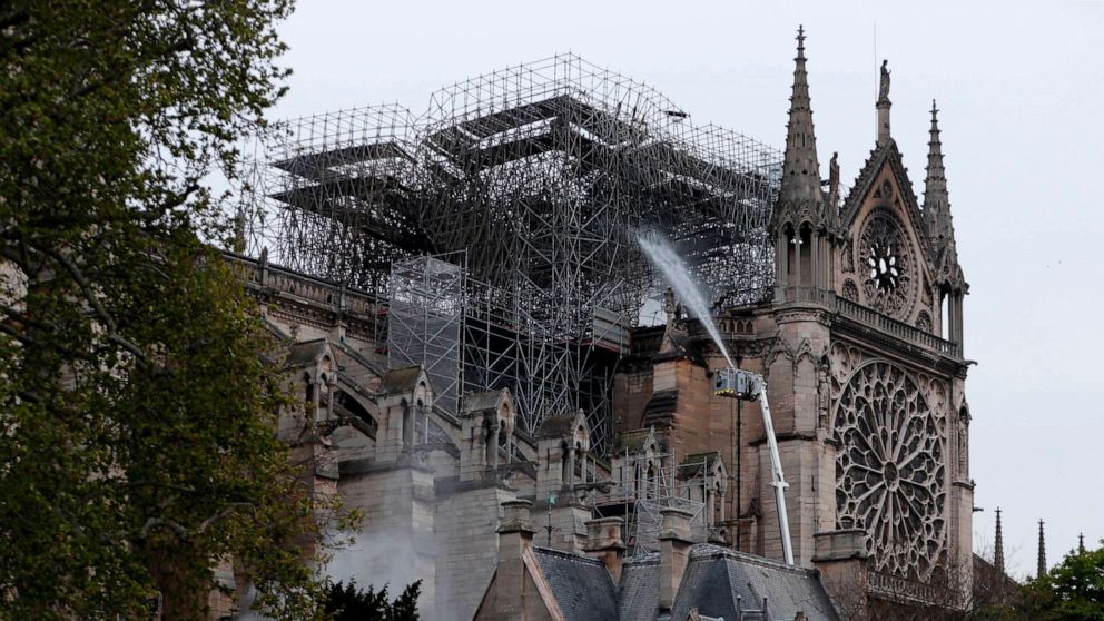 Firefighters spray water as they work to extinguish a fire at Notre-Dame Cathedral in Paris early on April 16, 2019.