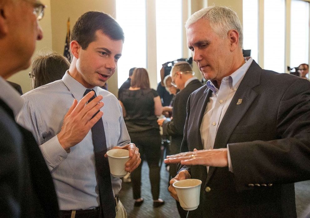 In this May 1, 2015, file photo, then-Indiana Gov. Mike Pence, right, talks with South Bend Mayor Pete Buttigieg during a visit to recap the legislative session that ends in South Bend.