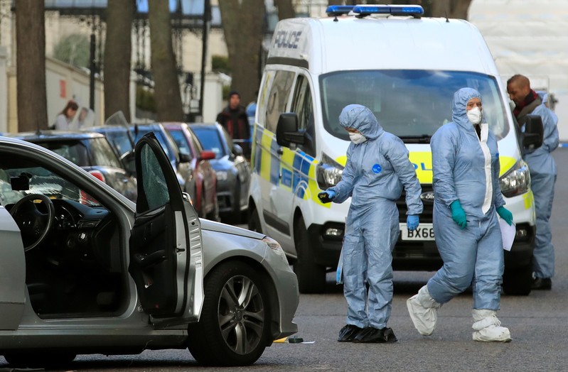Police forensics officers work at the site where police fired shots after a vehicle rammed the parked car of Ukraine's ambassador, outside the Ukrainian embassy in London