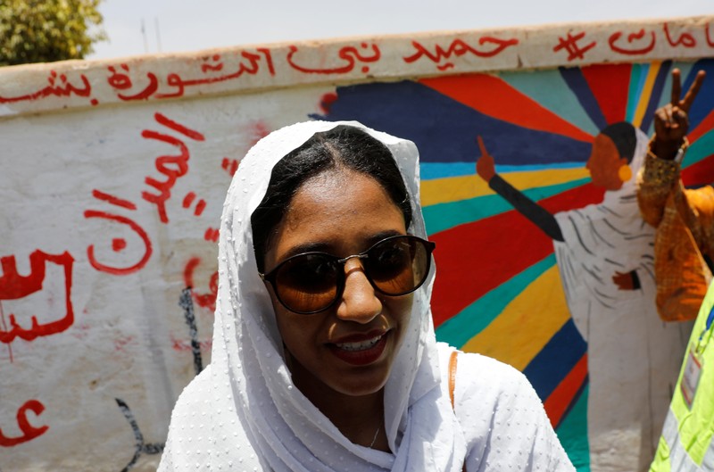 FILE PHOTO: Alaa Salah, a Sudanese protester whose video gone viral and make her an icon for the mass anti-government protests, stands in front of a mural depicting her in front of the Defence Ministry in Khartoum