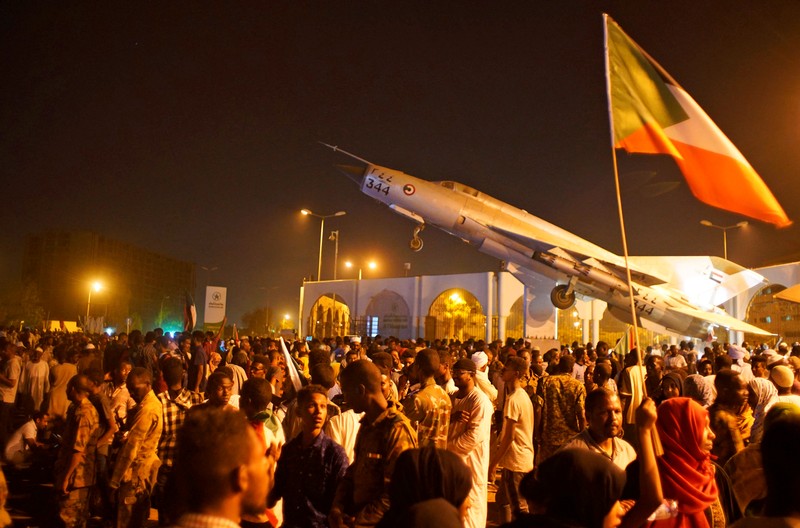 Sudanese demonstrators celebrate after the Defence Minister Awad Ibn Auf stepped down as head of the country's transitional ruling military council, as protesters demanded quicker political change, outside the Defence Ministry in Khartoum