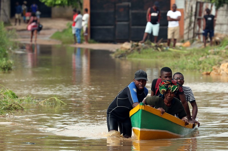 A man ferries residents through a flooded road in the aftermath of Cyclone Kenneth in Pemba