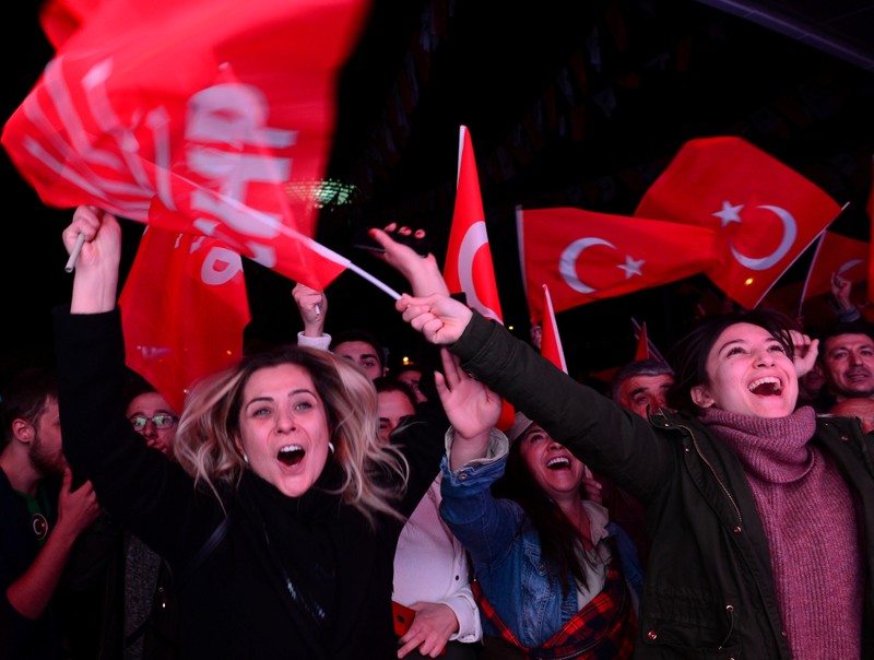Supporters of the main opposition CHP cheer in front of the party's headquarters as they celebrate the municipal elections results in Ankara
