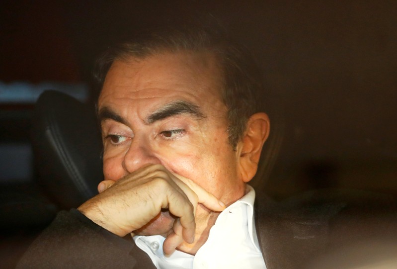FILE PHOTO: Former Nissan Motor Chairman Carlos Ghosn sits inside a car as he leaves his lawyer's office after being released on bail from Tokyo Detention House, in Tokyo