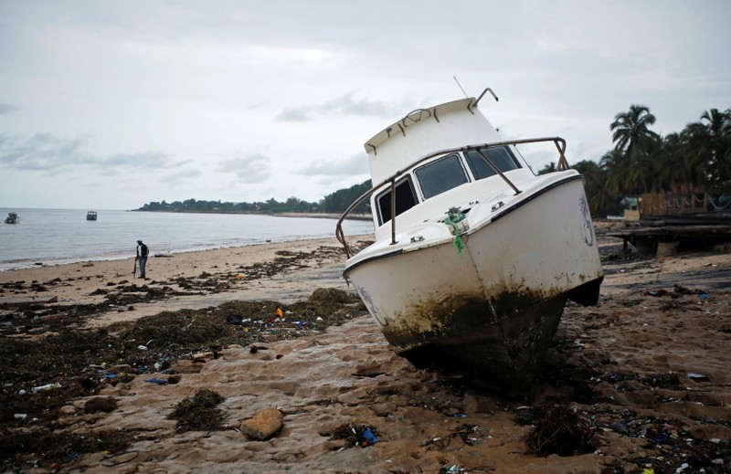 A washed up boat lies amongst storm debris on Wimbe beach in Pemba