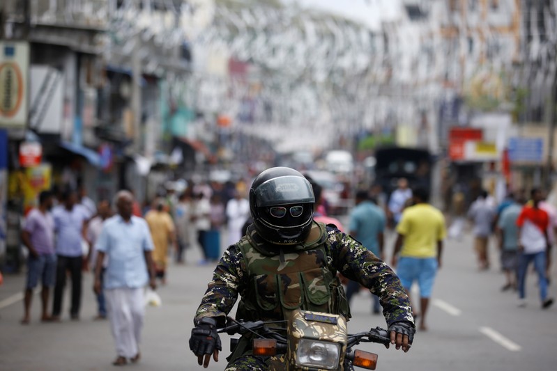 A member of the Sri Lankan security forces sits on a motorbike as he keeps watch outside St Anthony's Shrine in Colombo