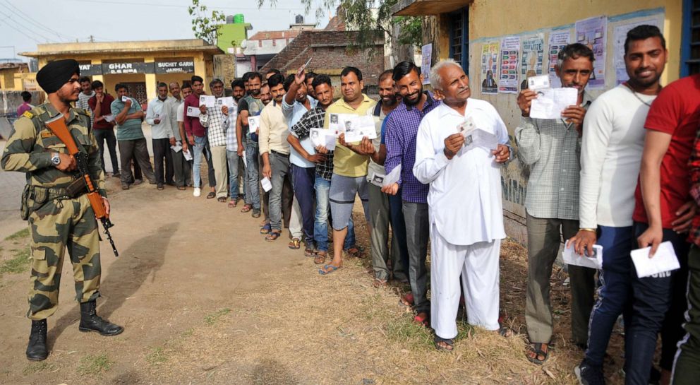 Voters stand in a queue to cast their votes at a polling booth for the first phase of general elections, April 11, 2019, in Jammu, India.