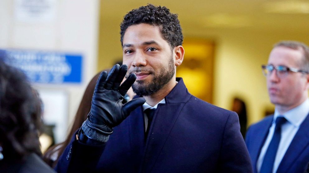 Jussie Smollett waves as he follows his attorney after his court appearance at Leighton Courthouse on March 26, 2019 in Chicago.