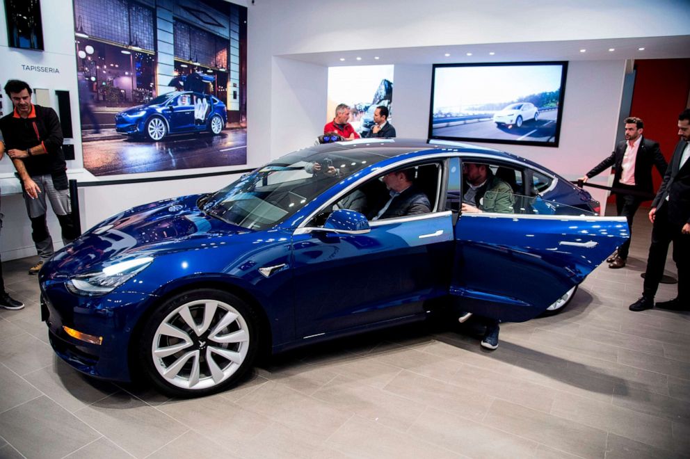 People check out a Tesla Model 3 during its first exhibition day in Spain, at the Tesla's store in Barcelona on Nov. 14, 2018.