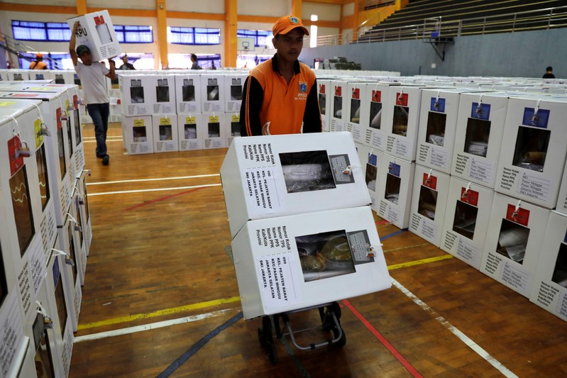 A worker carries election materials with a trolley to be distributed to polling stations from a warehouse in Jakarta