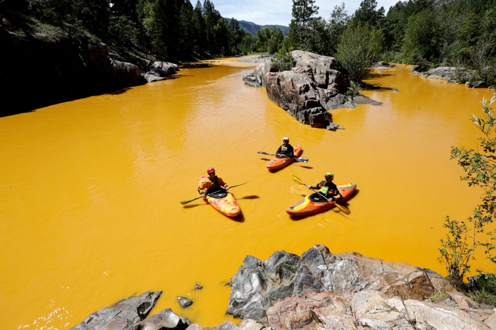 People kayak in the Animas River near Durango, Colo., in water colored from a mine waste spill, Aug. 6, 2015.