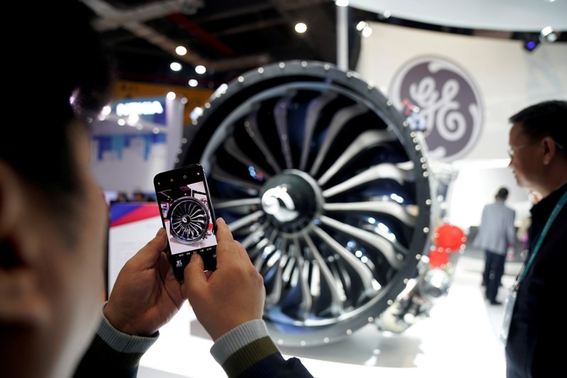 FILE PHOTO: A man takes a picture of a General Electric (GE) engine during the China International Import Expo (CIIE), at the National Exhibition and Convention Center in Shanghai