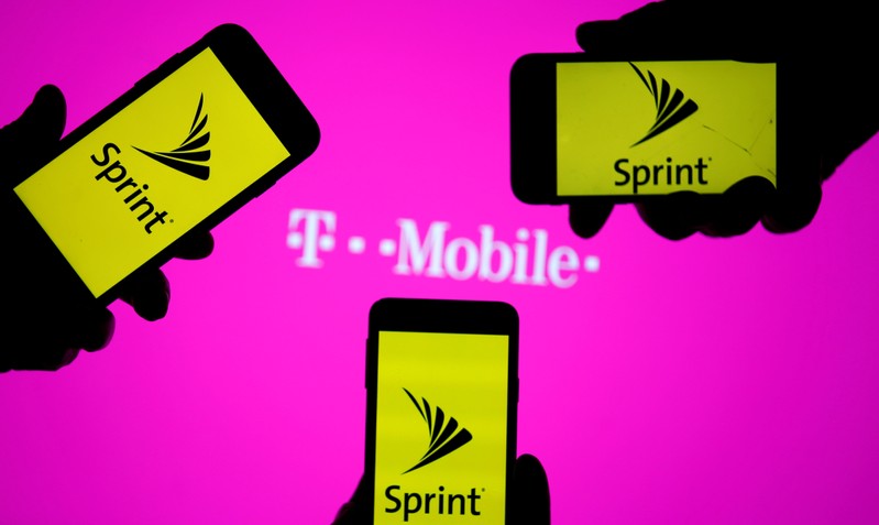 FILE PHOTO: A smartphones with Sprint logo are seen in front of a screen projection of T-mobile logo, in this picture illustration