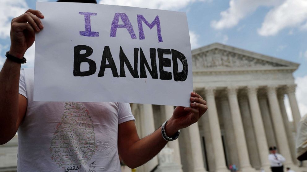 Mehrad Ansari of Iran holds a sign outside of the U.S. Supreme Court after U.S. President Trump's travel ban was upheld in Washington, D.C., June 26, 2018.