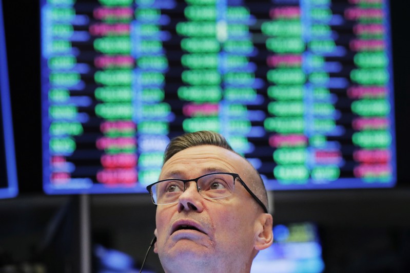 FILE PHOTO: A trader works on the floor of the New York Stock Exchange (NYSE) shortly after the opening bell in New York