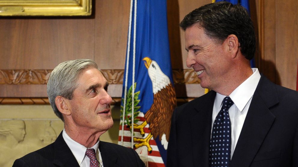 A Sept. 4, 2013 file photo showing incoming FBI Director James Comey, right, talking with retiring FBI Director Robert Mueller at the Justice Department in Washington,D.C. 