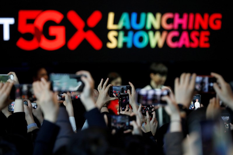 FILE PHOTO: People take photographs during a launching ceremony for SK Telecom's 5G service, in Seoul