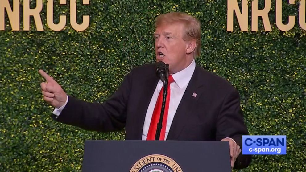 President Donald Trump mimics the movement of a windmill while delivering his speech at the NRCC Spring Dinner in Washington, April 2, 2019.