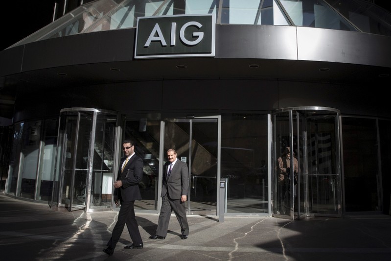 FILE PHOTO: People exit the AIG building in New York's financial district