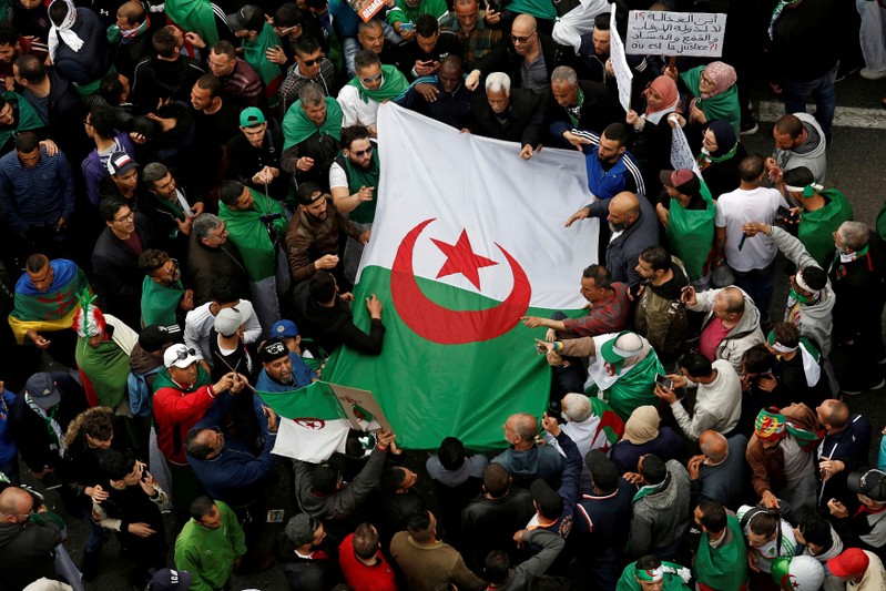 FILE PHOTO: Demonstrators hold flags and banners as they return to the streets to press demands for wholesale democratic change well beyond former president Abdelaziz Bouteflika's resignation in Algiers