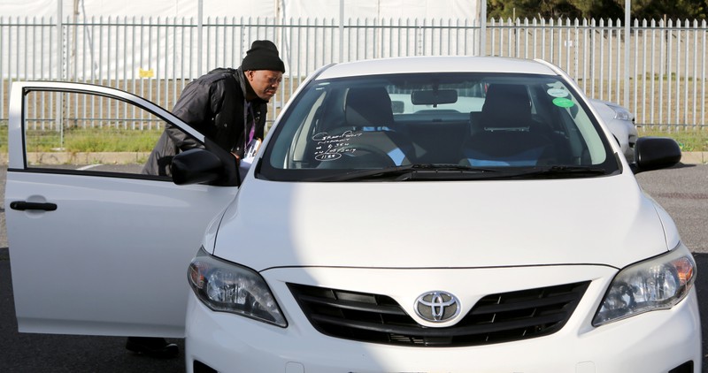 A traffic official checks an impounded Uber vehicle during a clampdown on drivers operating without permits in Cape Town
