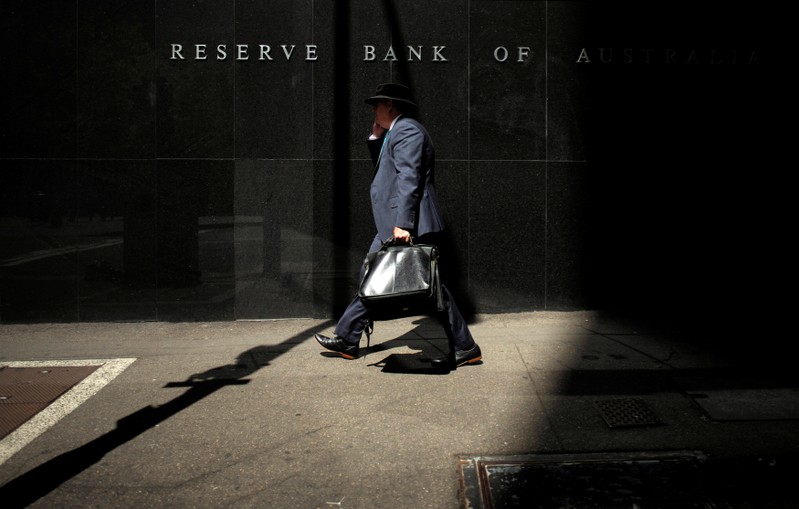 FILE PHOTO: A Sydney businessman walks into the light outside the Reserve Bank of Australia