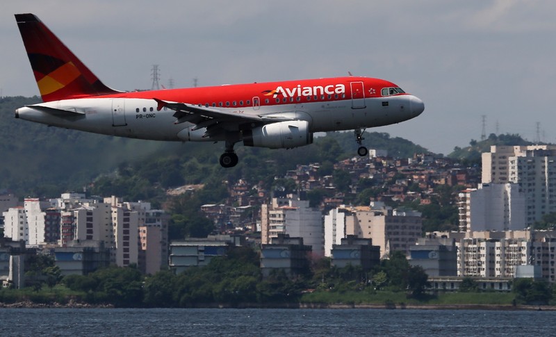 FILE PHOTO: An Airbus A318 airplane of Avianca Brazil flies over the Guanabara Bay as it prepares to land at Santos Dumont airport in Rio de Janeiro