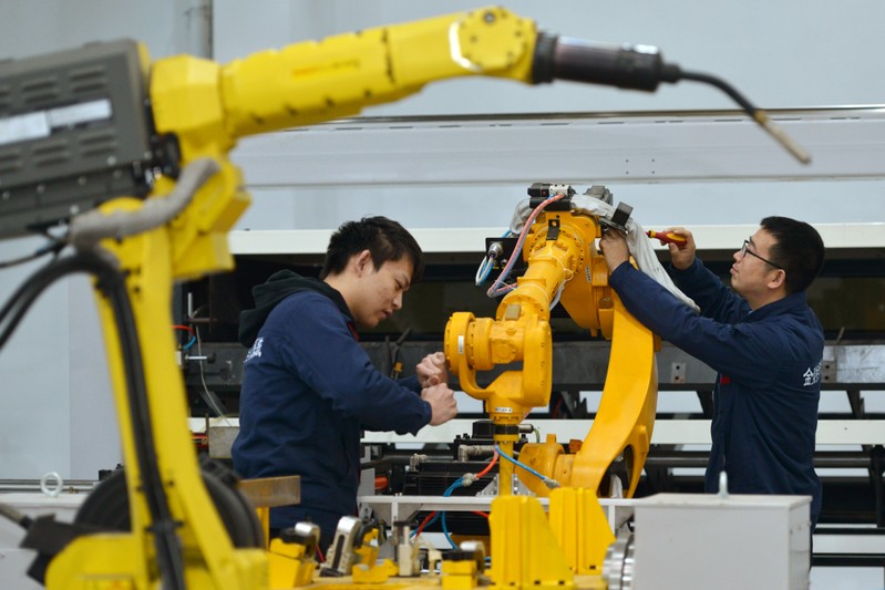 Men work on a production line manufacturing robotic arms at a factory in Huzhou, Zhejiang