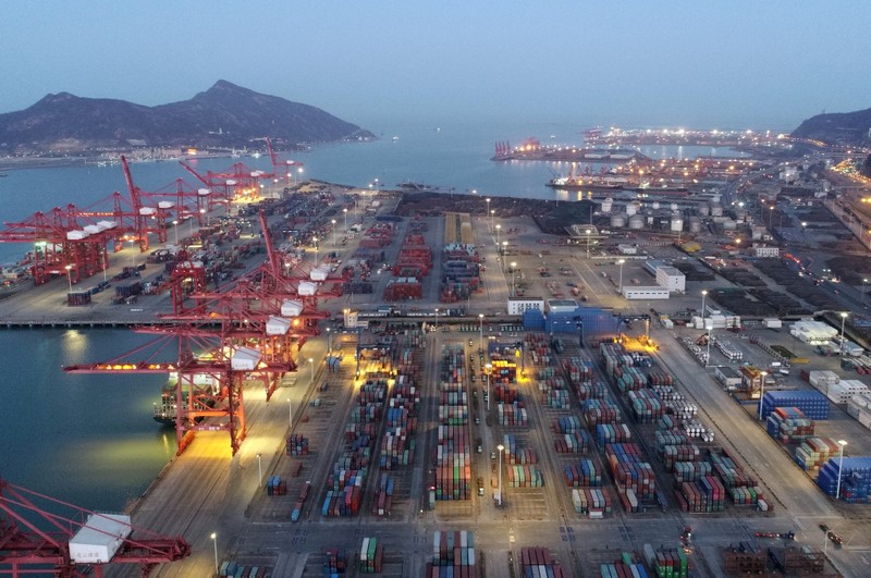 FILE PHOTO: Containers and cargo vessels are seen at sunset at a port in Lianyungang