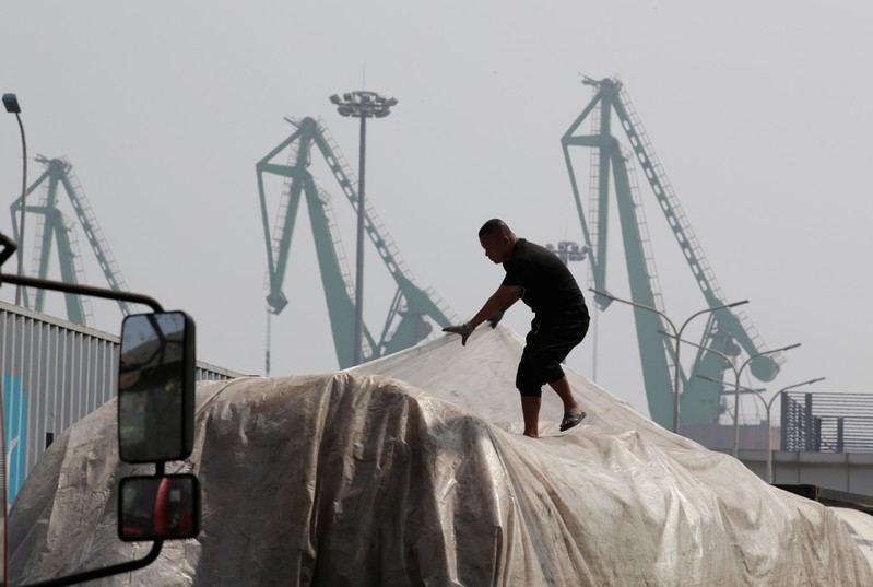 A labourer works outside a logistics center near Tianjin Port