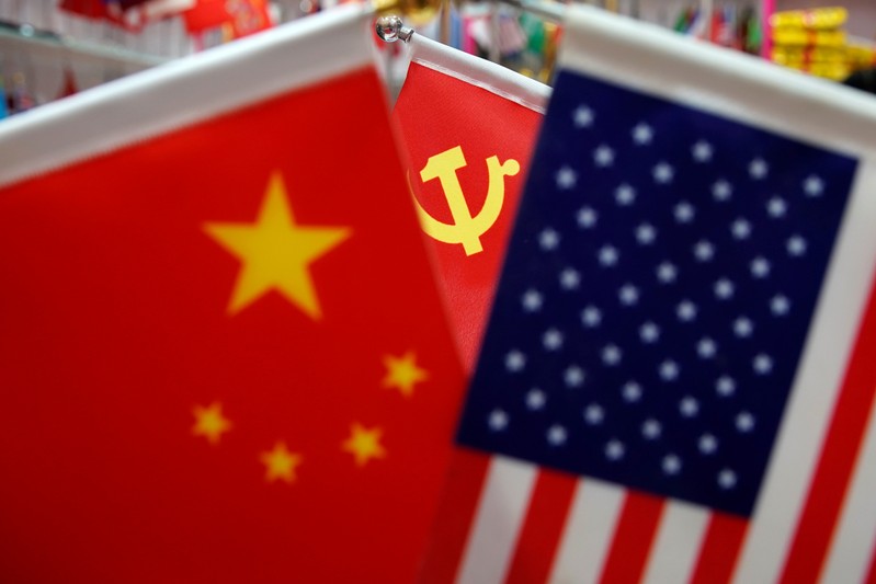 The flags of China, U.S. and the Chinese Communist Party are displayed in a flag stall at the Yiwu Wholesale Market in Yiwu
