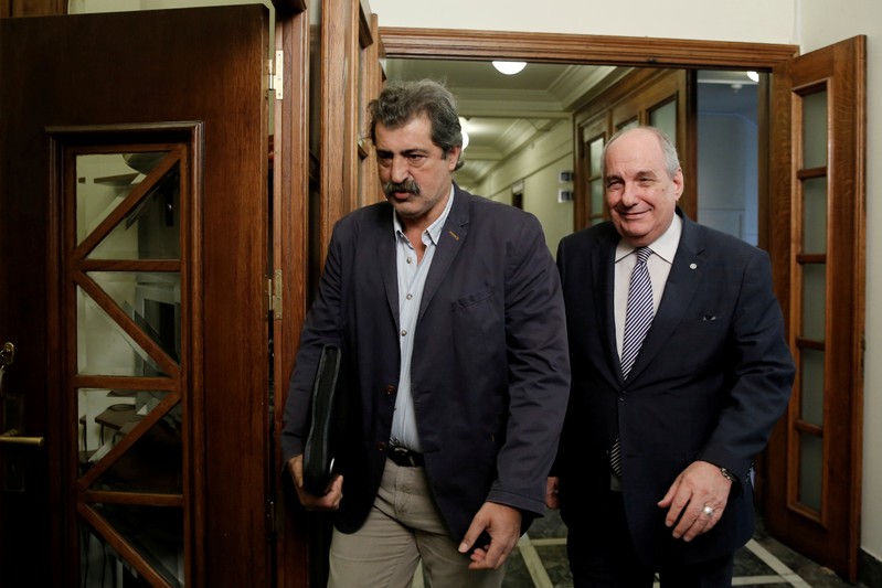 FILE PHOTO: Greek Deputy health minister Pavlos Polakis and Greek Deputy Minister of Foreign Affairs Terens Quick arrive for a cabinet meeting at the parliament in Athens