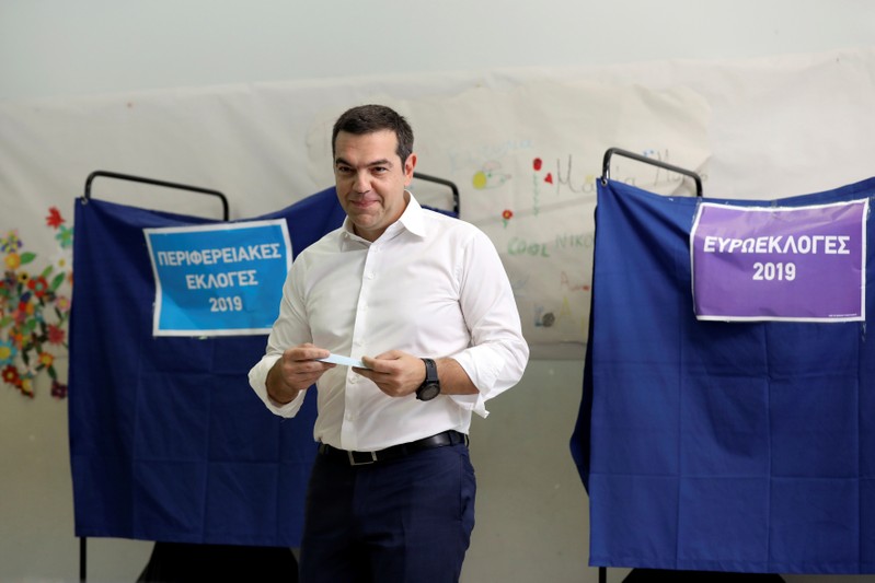 Greek PM Tsipras holds his ballot before voting for the European and local elections at a polling station in Athens
