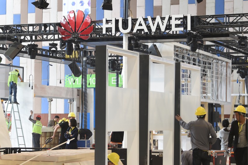 Workers are seen near the booth of Huawei Technologies Co under construction at the venue of China International Big Data Industry Expo in Guiyang