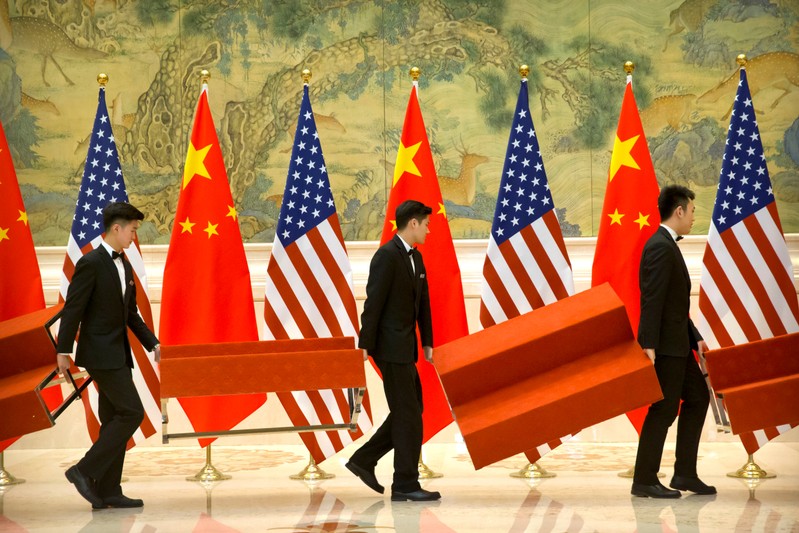 FILE PHOTO: Aides set up platforms before a group photo with members of U.S. and Chinese trade negotiation delegations at the Diaoyutai State Guesthouse in Beijing