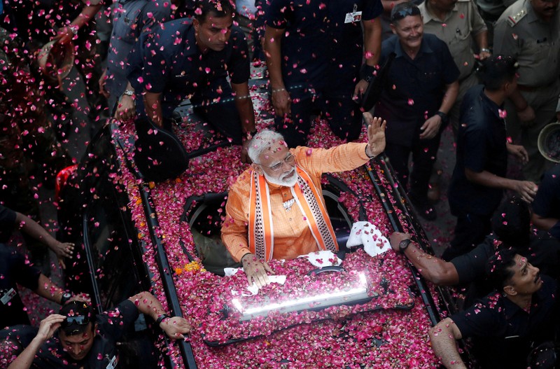 FILE PHOTO: India's Prime Minister Narendra Modi waves towards his supporters during a roadshow in Varanasi