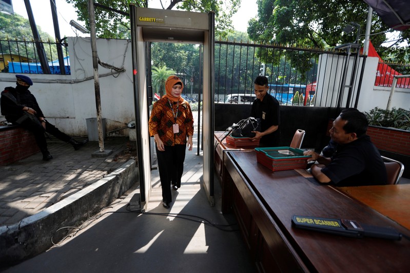 A woman walks passed a metal detector as she enters the General Election Commission (KPU) headquarters, ahead of the announcement of the presidential election results after the last month election in Jakarta