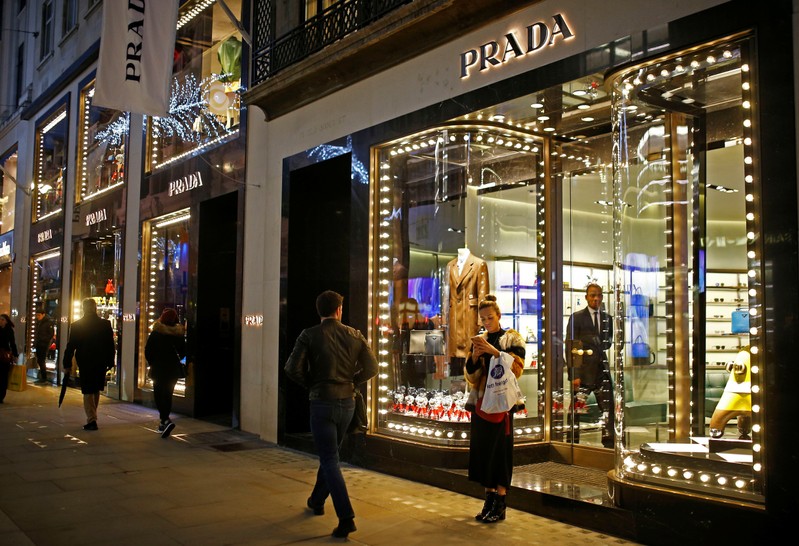 Festive lights decorate the Prada store on New Bond Street as shoppers do Christmas shopping in central London