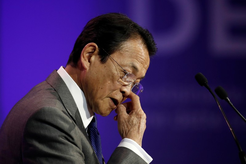 FILE PHOTO: Japanese Finance Minister Taro Aso delivers a speech during a high-level forum on debt at the Finance Ministry in Paris