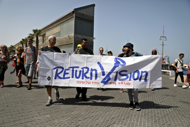 People hold a banner as they take part in an anti Israel protest ahead of the Grand Final of 2019 Eurovision Song Contest in Tel Aviv