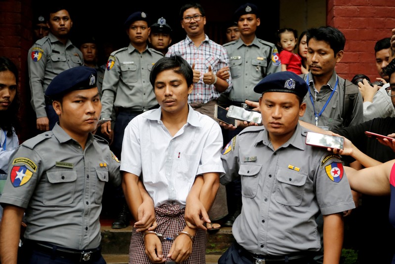 FILE PHOTO: Detained Reuters journalist Kyaw Soe Oo and Wa Lone are escorted by police as they leave after a court hearing in Yangon
