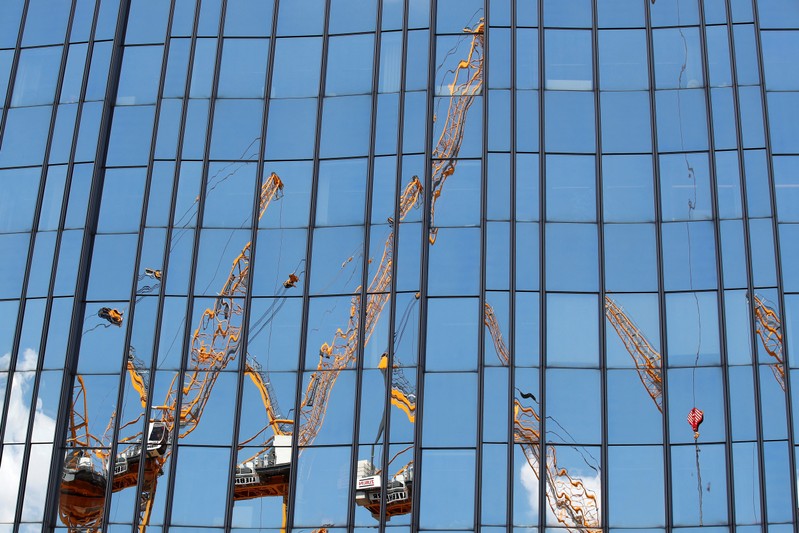 A construction site is reflected on a skyscraper facade in Berlin