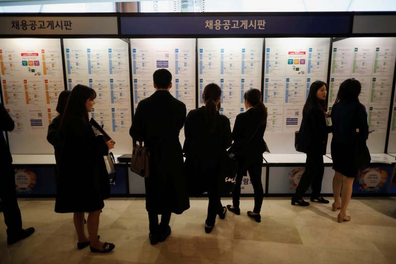 Jobseekers look at recruitment advertisements during the 2018 Japan Job Fair in Seoul