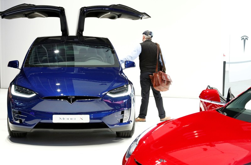 A visitor inspects a Tesla Model X electric vehicle at Brussels Motor Show