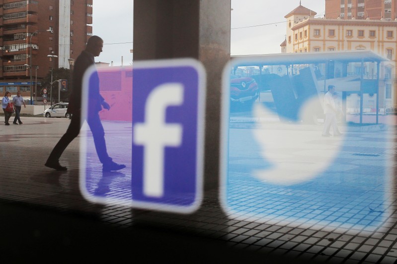 FILE PHOTO: Facebook and Twitter logos are seen on a shop window in Malaga