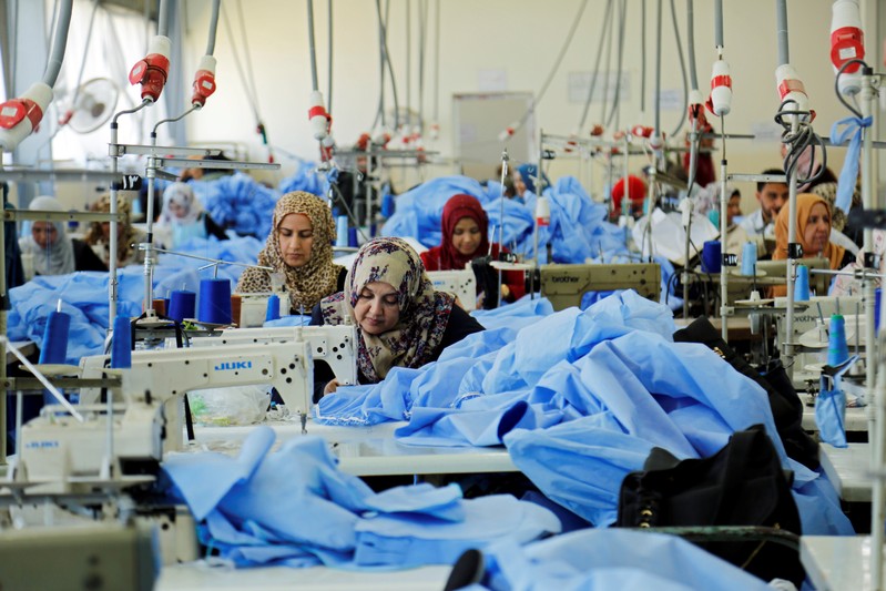 Women sew clothes at Waladi textile factory, part of which was destroyed by the war in Mosul