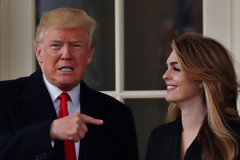 U.S. President Trump reacts as he stands next to former White House Communications Director Hope Hicks outside of the Oval Office as he departs for a trip to Cleveland, Ohio, in Washington D.C.