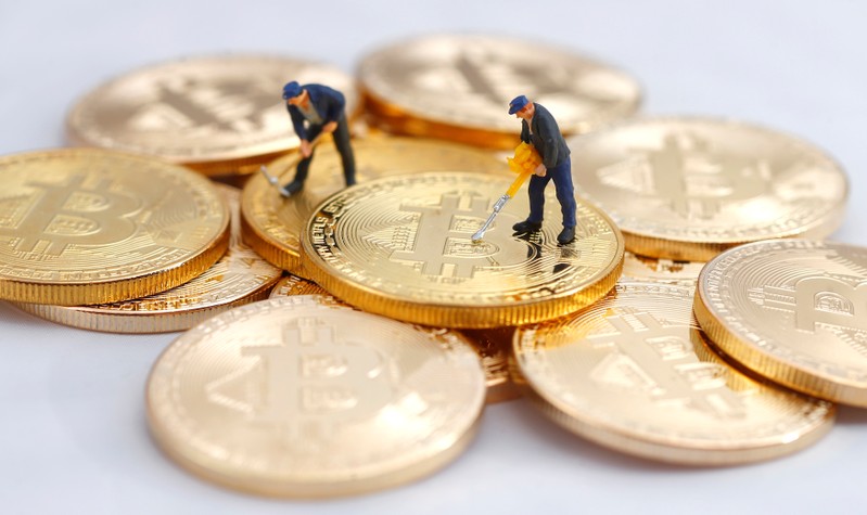 Small toy figures are seen on representations of the Bitcoin virtual currency in this illustration picture