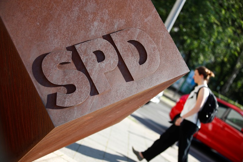 Person walks past the logo of Germany's SPD at the party's headquarters in Berlin