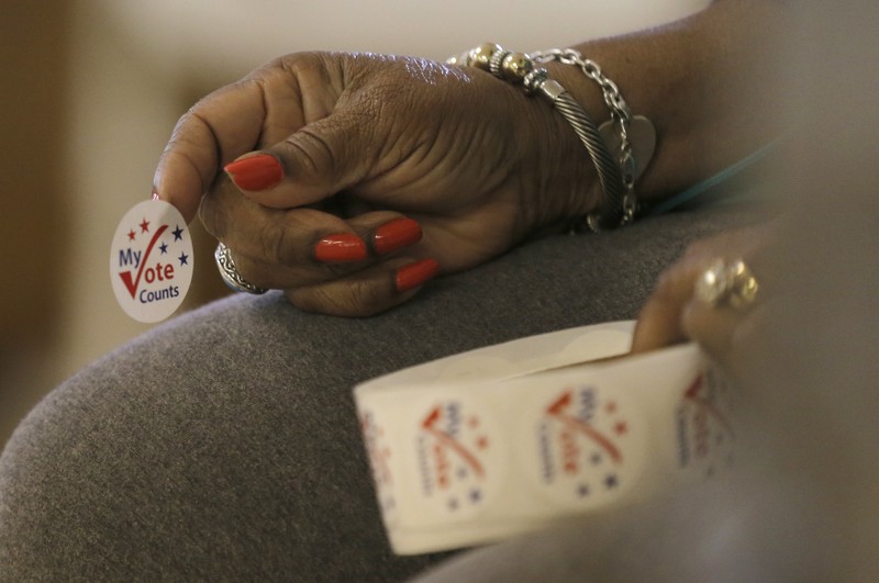 A worker holds stickers for voters at a polling station at the Princeton Baptist Church during the U.S. presidential election, in Princeton, North Carolina